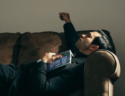 Homme se relaxant sur son canapé avec un livre